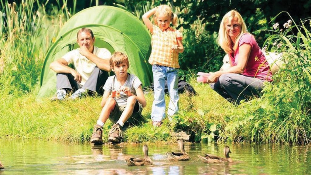 Family wild camping by lake